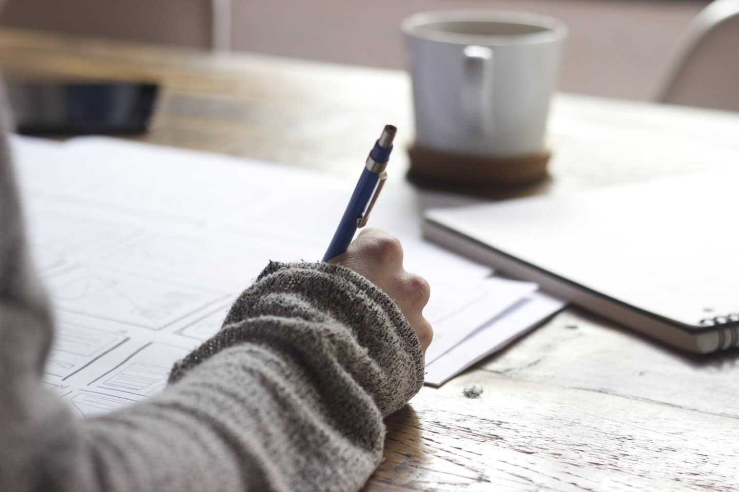Person schreibt handschriftliche Lernstrategien in ein Notizbuch.
